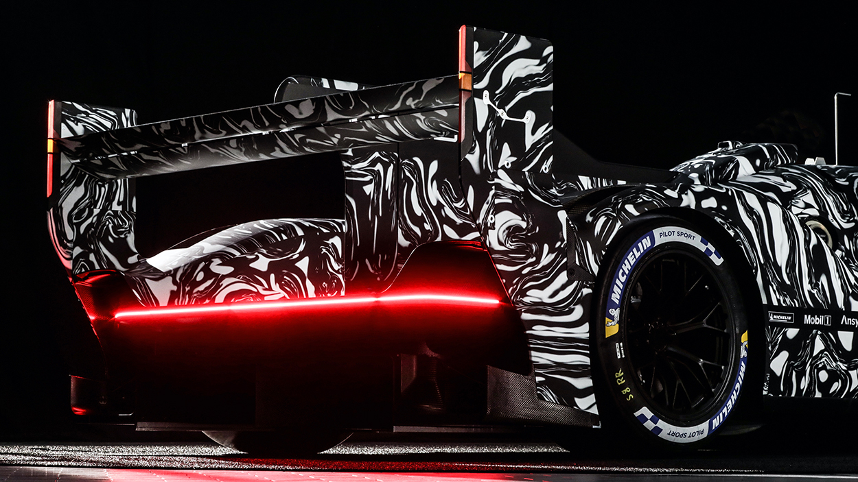 Porsche shows us the rear of its new, still-heavily-camouflaged LMDh ...